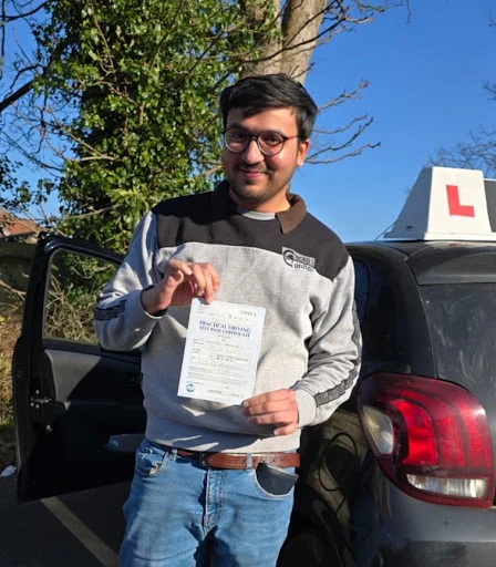 Dr. Khurram holding pass certificate outside Folkestone Driving Test Centre